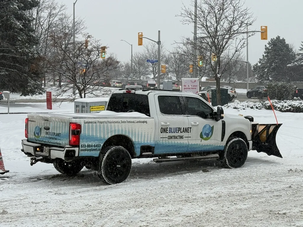 Branded OneBluePlanet plow truck at an Ottawa commercial property