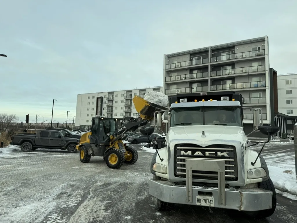 Loader filling a dump truck during commercial snow hauling