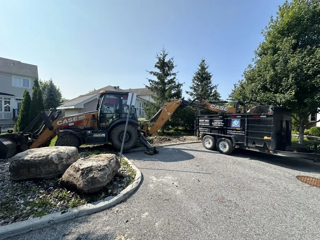 OneBluePlanet Case backhoe beside branded dump trailer