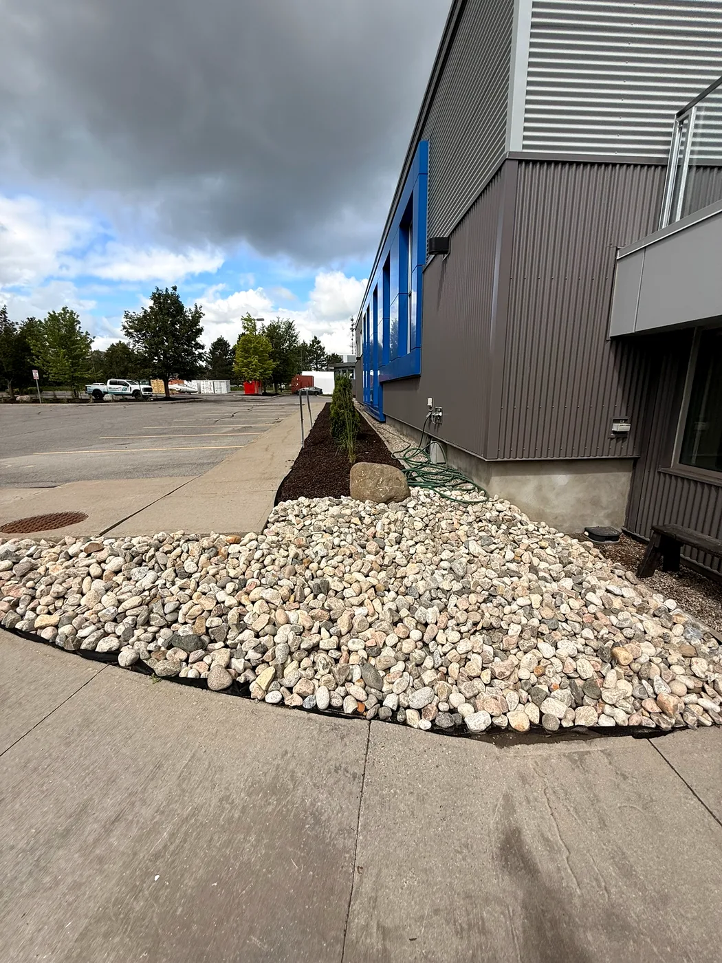 Finished riverstone landscape bed along a commercial building