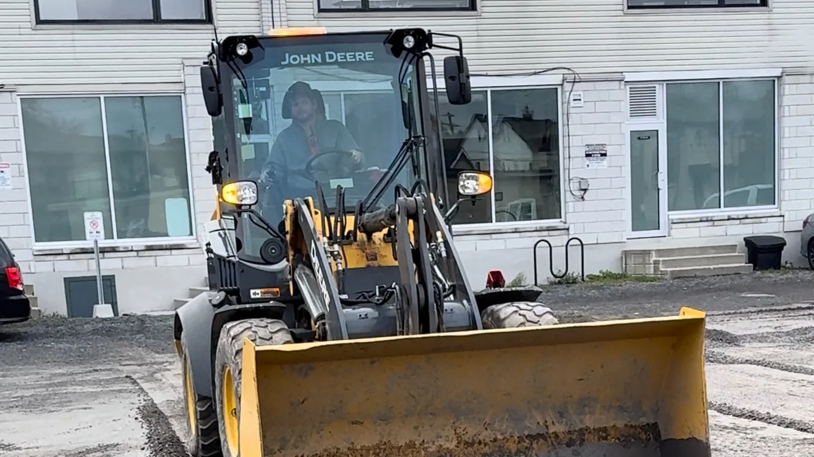 Loader grading and repairing a commercial exterior surface